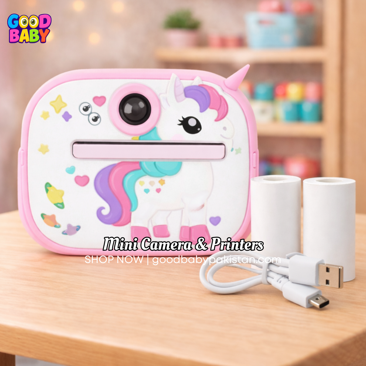 Unicorn-shaped mini camera and printer on a wooden surface with 'Good Baby' branding.